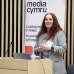 a woman with red hair presenting to an audience