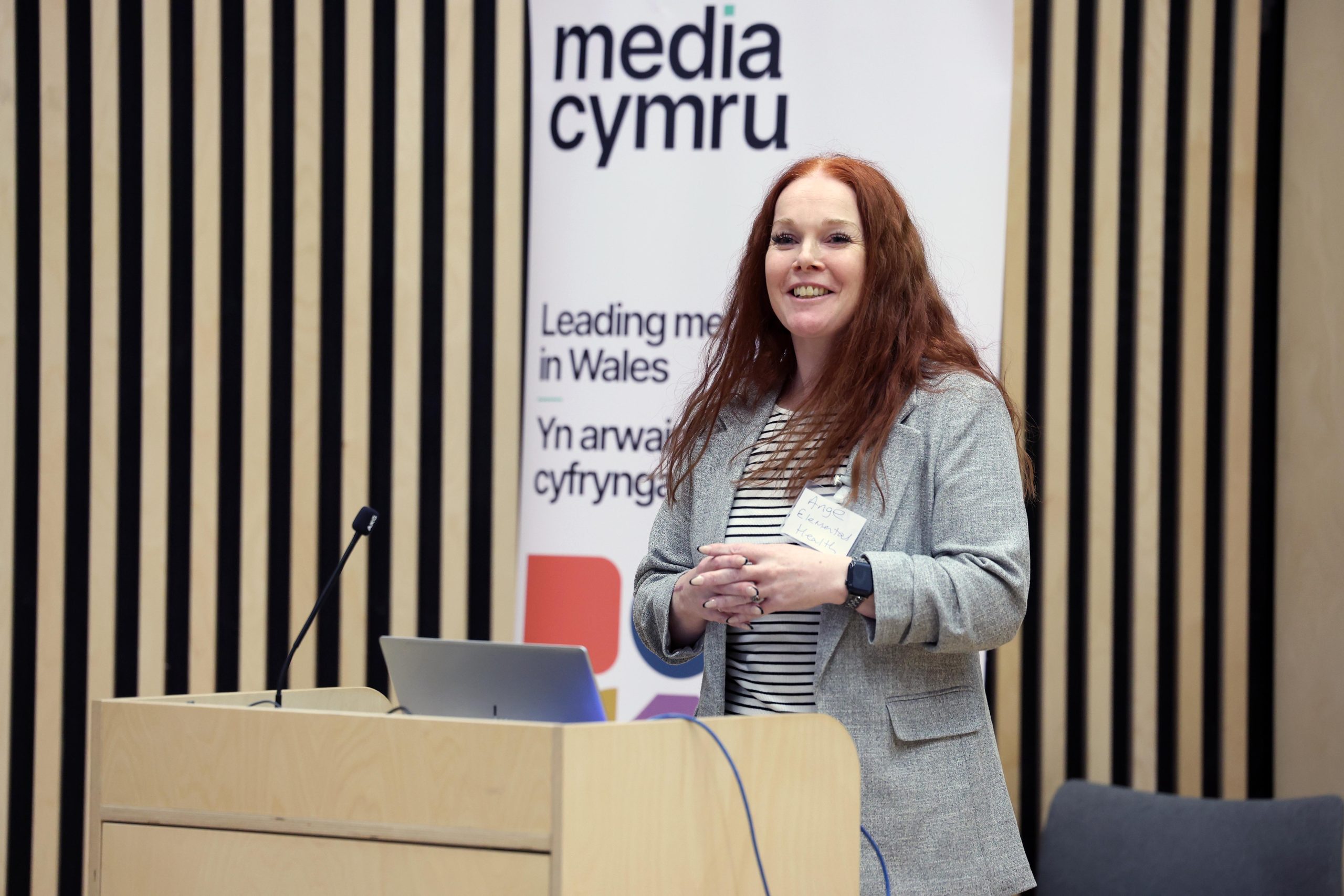 a woman with red hair presenting to an audience