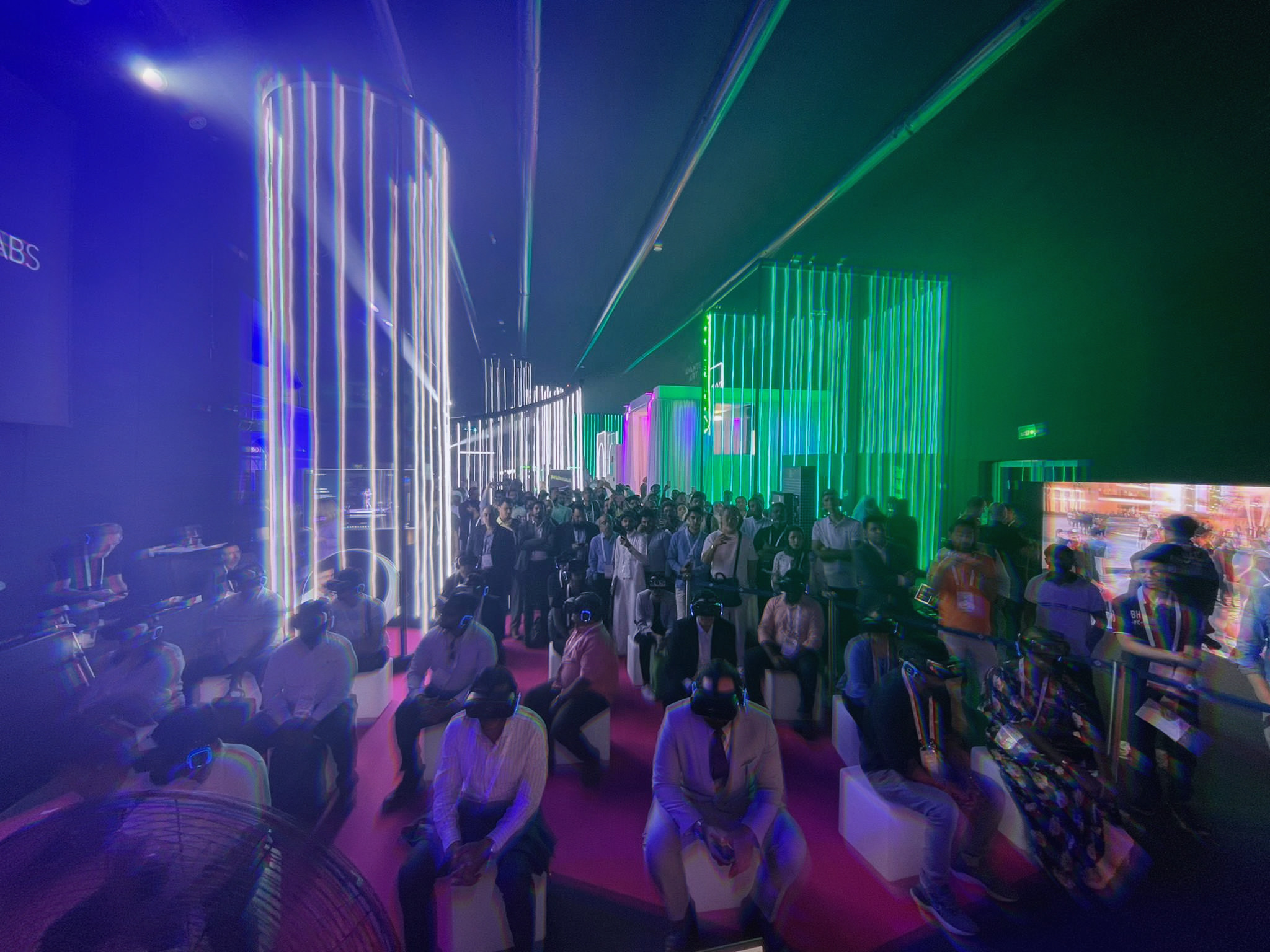 crowds of people in a room with green and white strobe lights