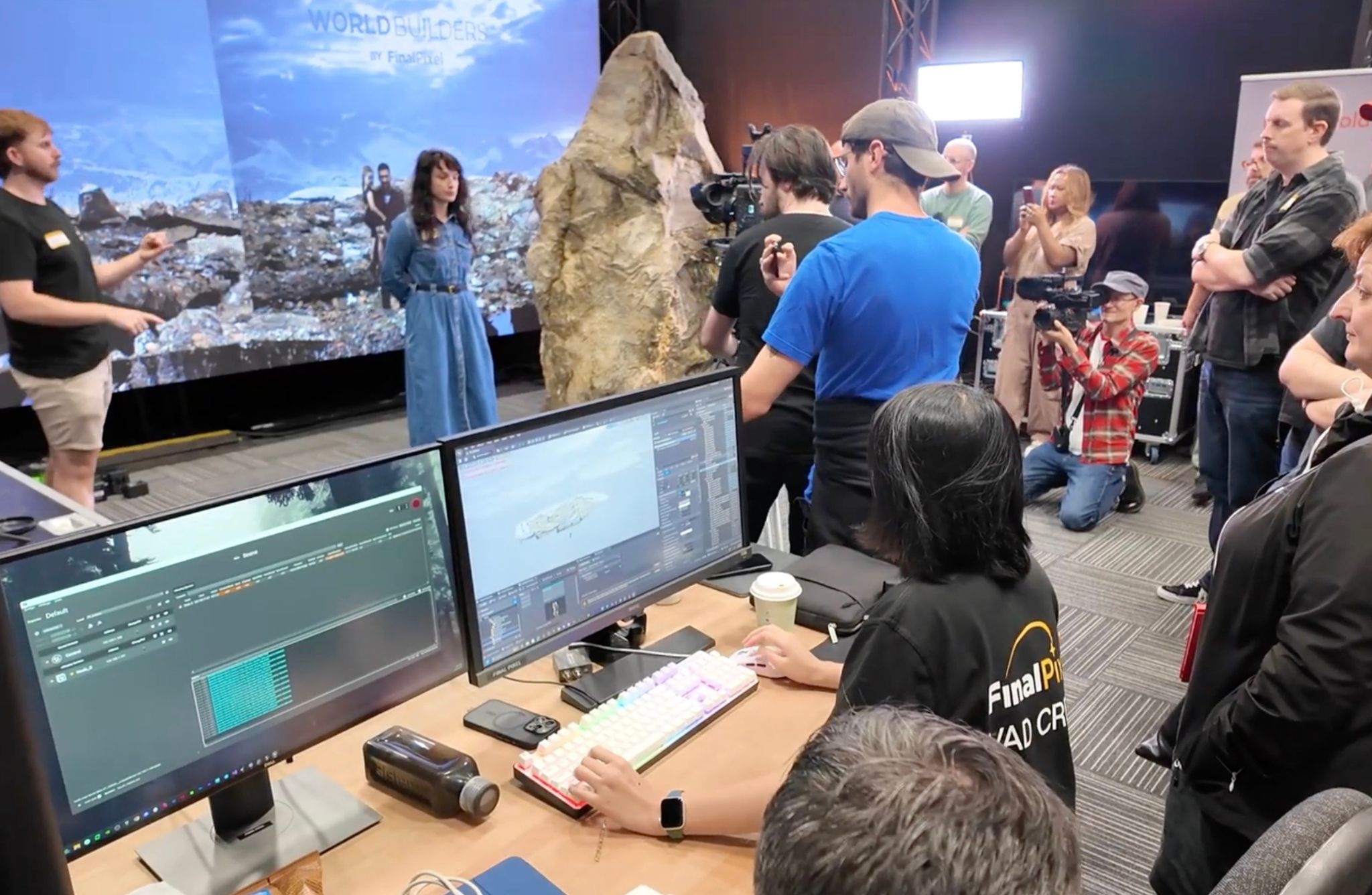 A behind-the-scenes studio scene with cameras, monitors, and crew gathered around a live virtual production demonstration.